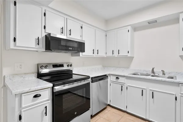 a kitchen with cabinets appliances a sink and a counter top