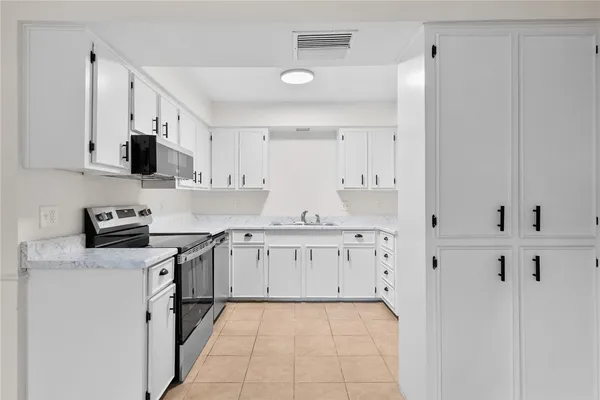a kitchen with stainless steel appliances a stove top oven