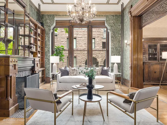 a living room with furniture a fireplace and a chandelier