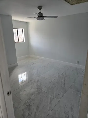 en empty room with windows and fan