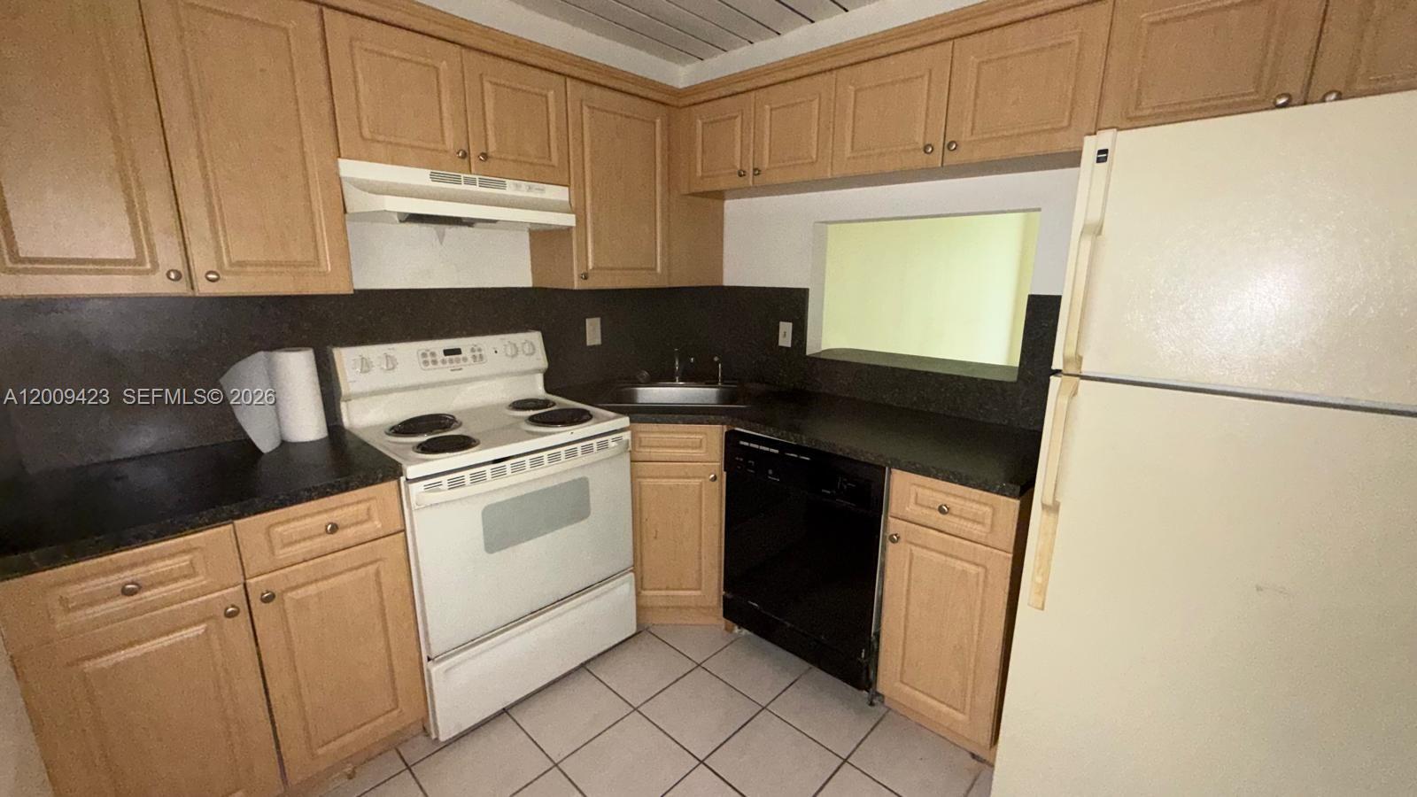 3774 Inverrary Boulevard, Unit 105P Lauderhill, FL 33319 - Photo 6 of 13 a kitchen with a sink and a refrigerator