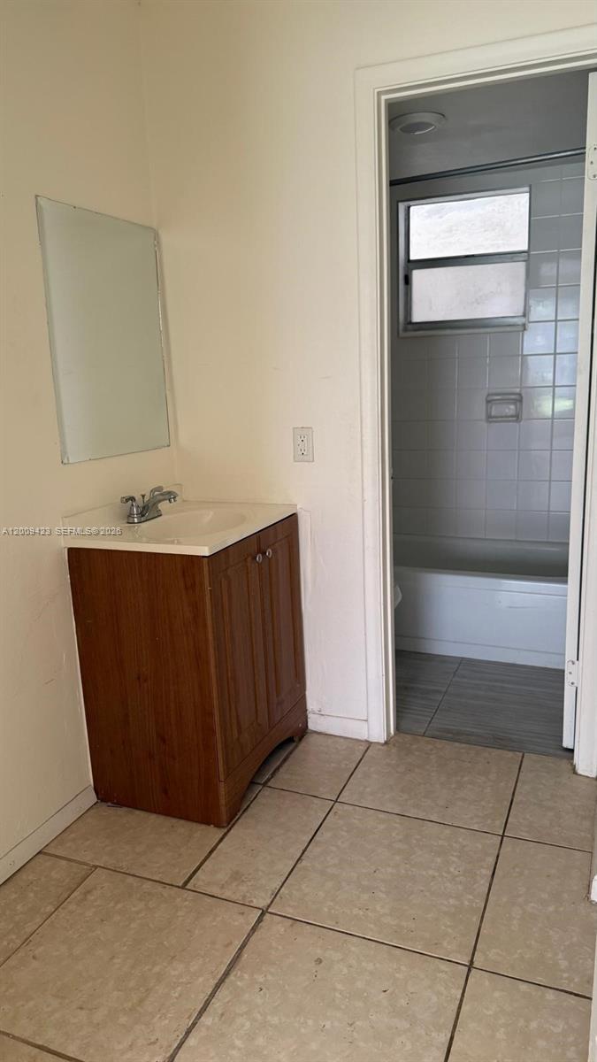 3774 Inverrary Boulevard, Unit 105P Lauderhill, FL 33319 - Photo 9 of 13 a bathroom with a sink a toilet and large mirror