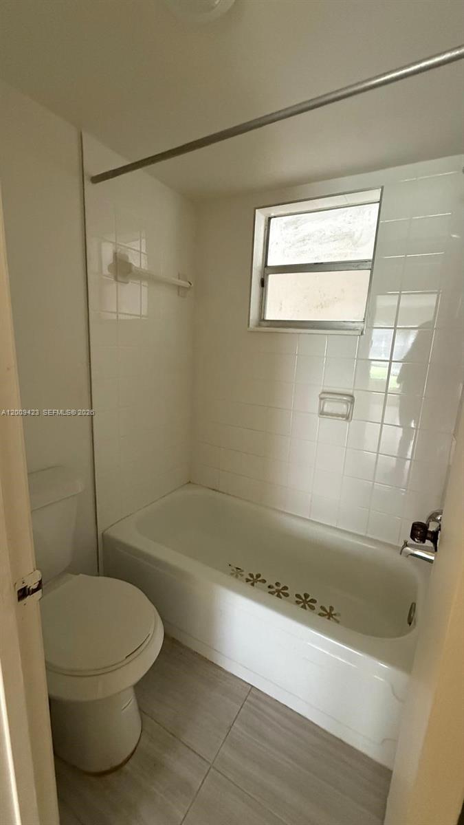 3774 Inverrary Boulevard, Unit 105P Lauderhill, FL 33319 - Photo 10 of 13 a bathroom with a toilet and a bath tub