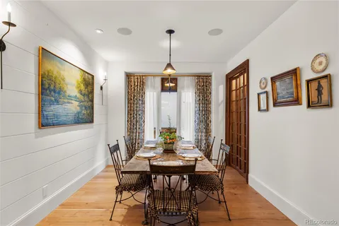 a dining room with furniture a chandelier and wooden floor