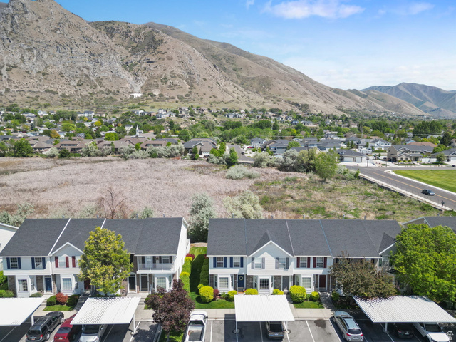 732 North 200 E Street Springville, UT 84663 - Photo 32 of 36 Townhome complex with mountain backdrop, featuring two-story residences with gabled roofs and individual carports