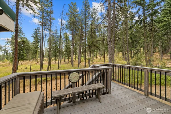 a view of wooden deck and a yard with wooden fence