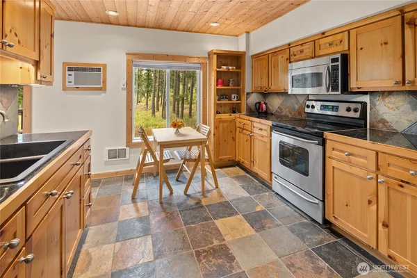 a kitchen with stainless steel appliances granite countertop a stove a sink and a microwave