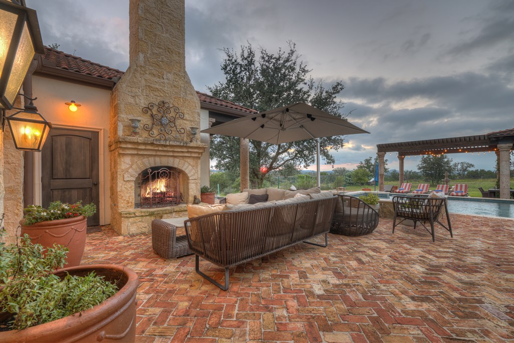 2975 Bear Creek Road Fredericksburg, TX 78624 - Photo 35 of 53 a living room with furniture a fireplace and a table
