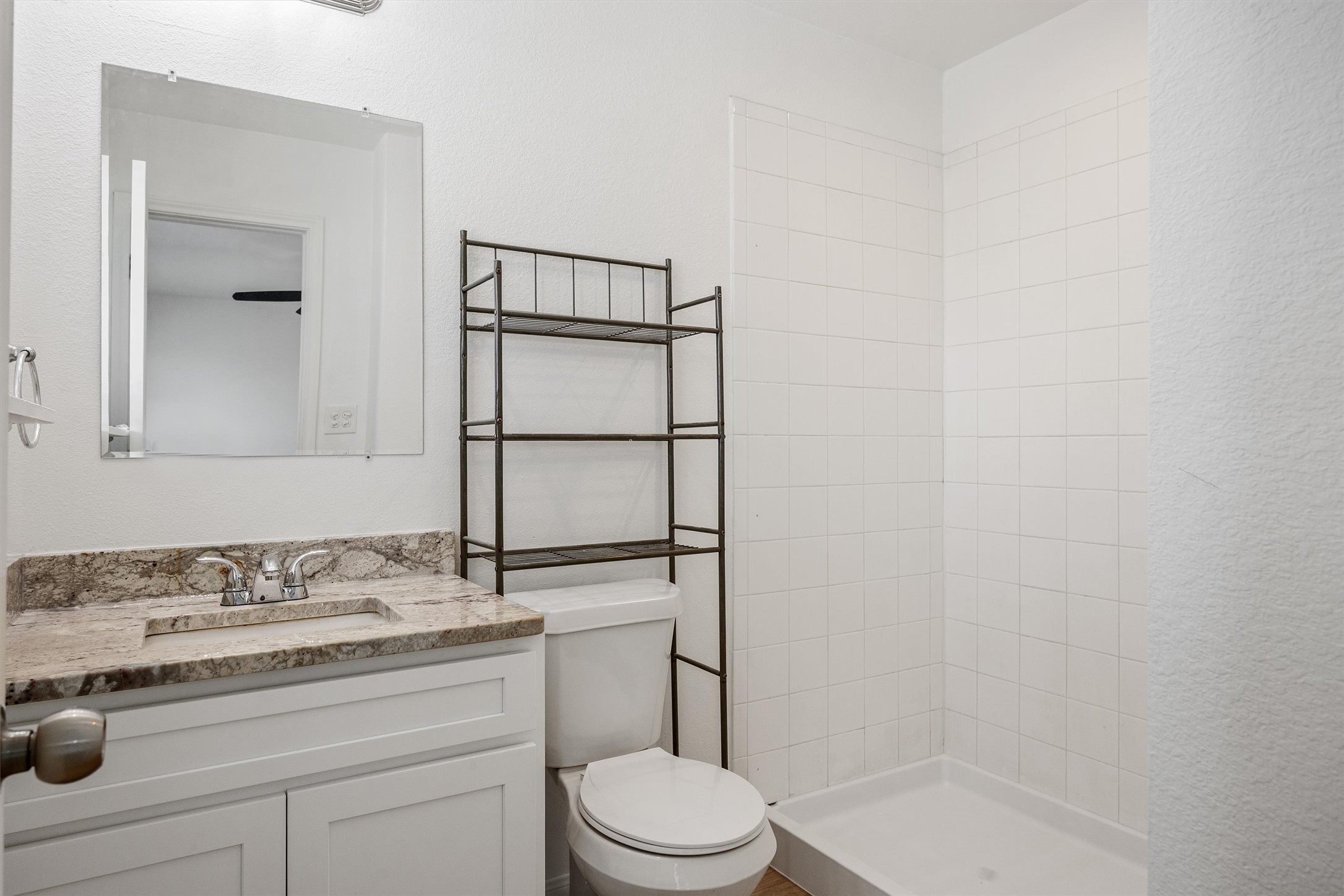 4516 Kind Way, Unit 253 Austin, TX 78725 - Photo 21 of 31 a bathroom with a granite countertop toilet sink and mirror