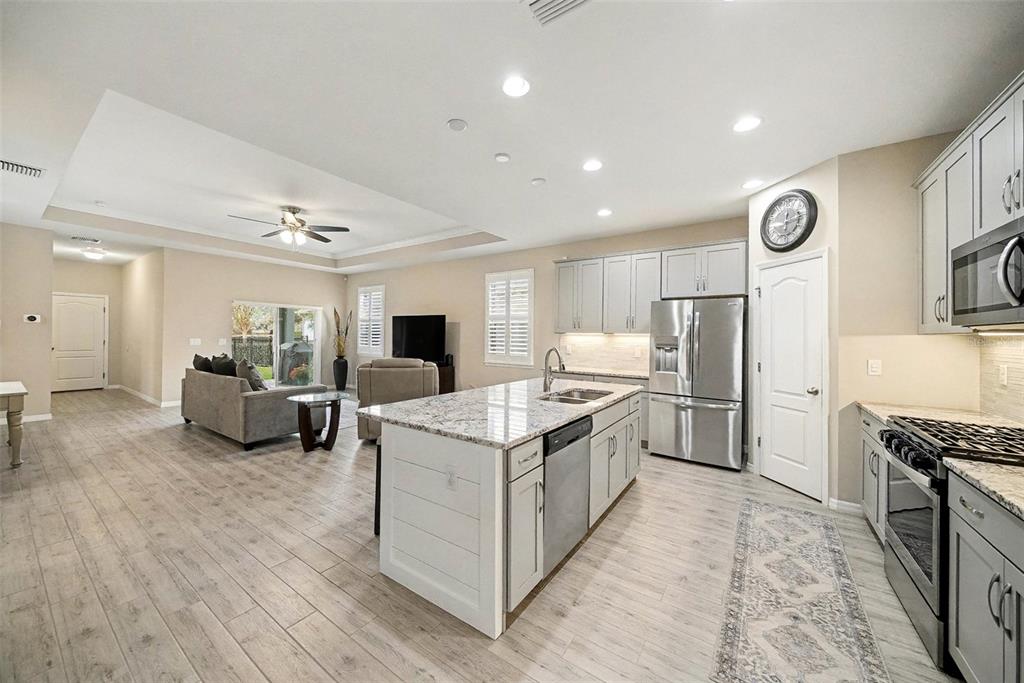 14902 Caravan Avenue Odessa, FL 33556 - Photo 14 of 40 a open kitchen with stainless steel appliances granite countertop a stove and a refrigerator