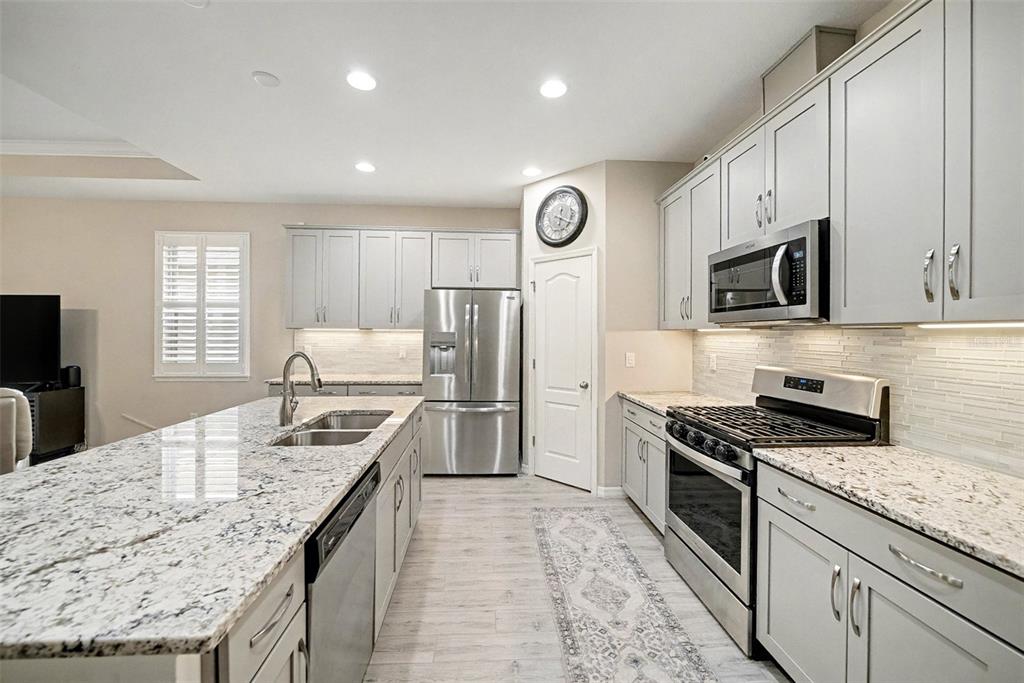 14902 Caravan Avenue Odessa, FL 33556 - Photo 16 of 40 a kitchen with granite countertop a stove top oven microwave and refrigerator