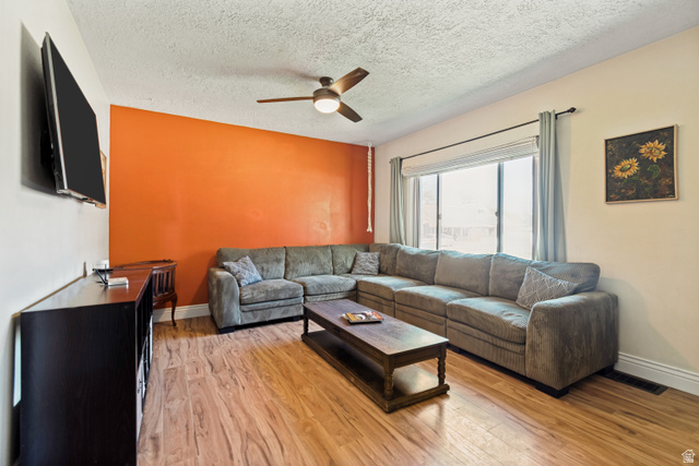 127 West 300 North Springville, UT 84663 - Photo 6 of 24 Spacious room featuring wood flooring, a contemporary ceiling fan, and a large window with drapes
