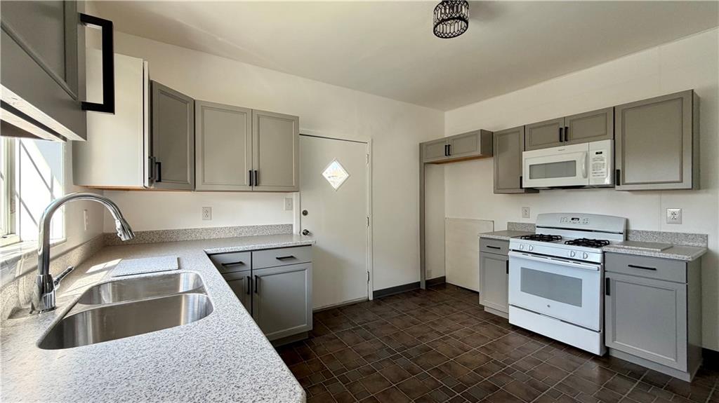 641 Garfield Street Springdale, PA 15144 - Photo 13 of 44 a kitchen with granite countertop a sink a stove and refrigerator