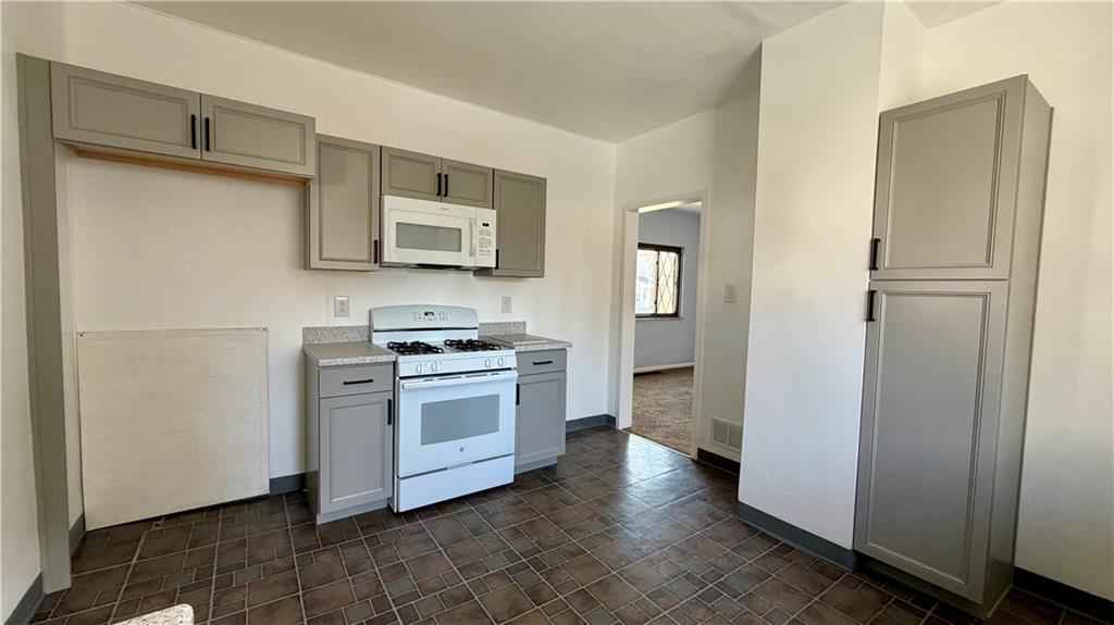 641 Garfield Street Springdale, PA 15144 - Photo 16 of 44 a kitchen with white cabinets and stainless steel appliances