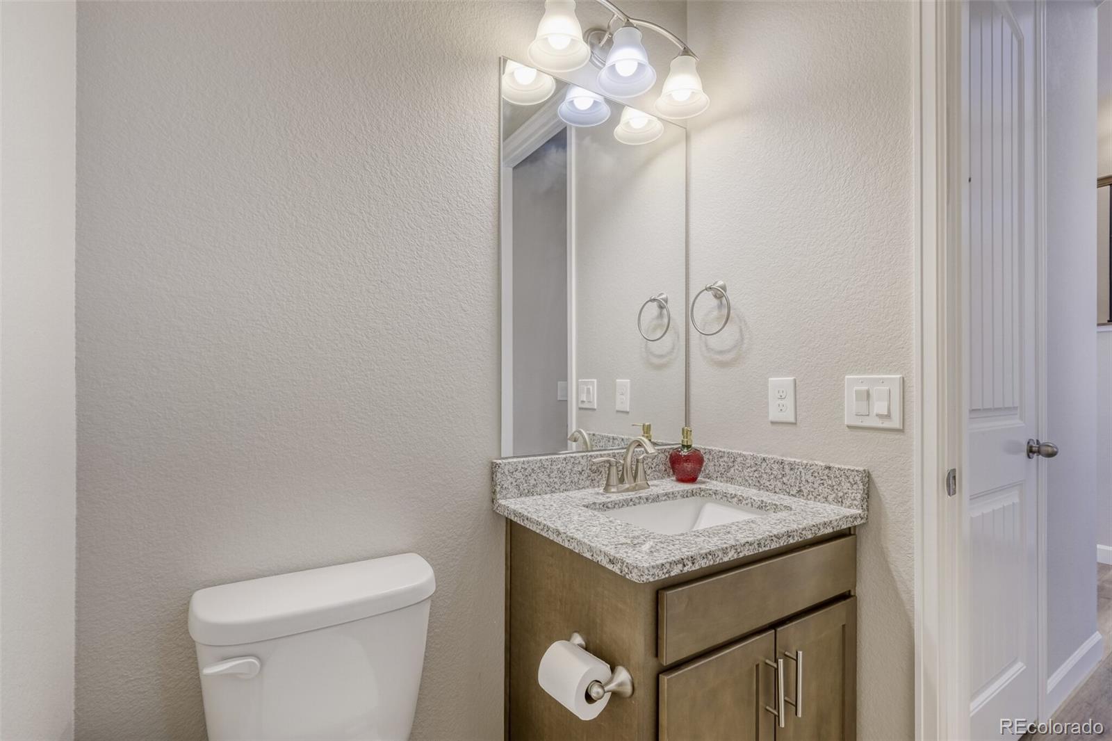 9093 Peaceful Valley Road Colorado Springs, CO 80925 - Photo 15 of 42 a bathroom with a granite countertop sink and a mirror