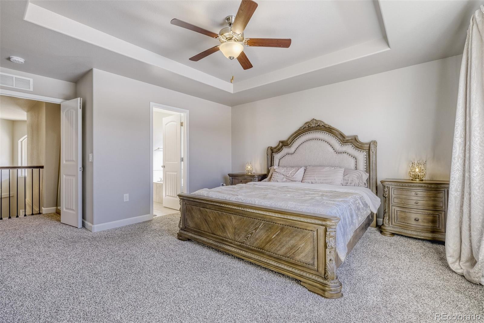 9093 Peaceful Valley Road Colorado Springs, CO 80925 - Photo 17 of 42 a bedroom with a bed and a chandelier