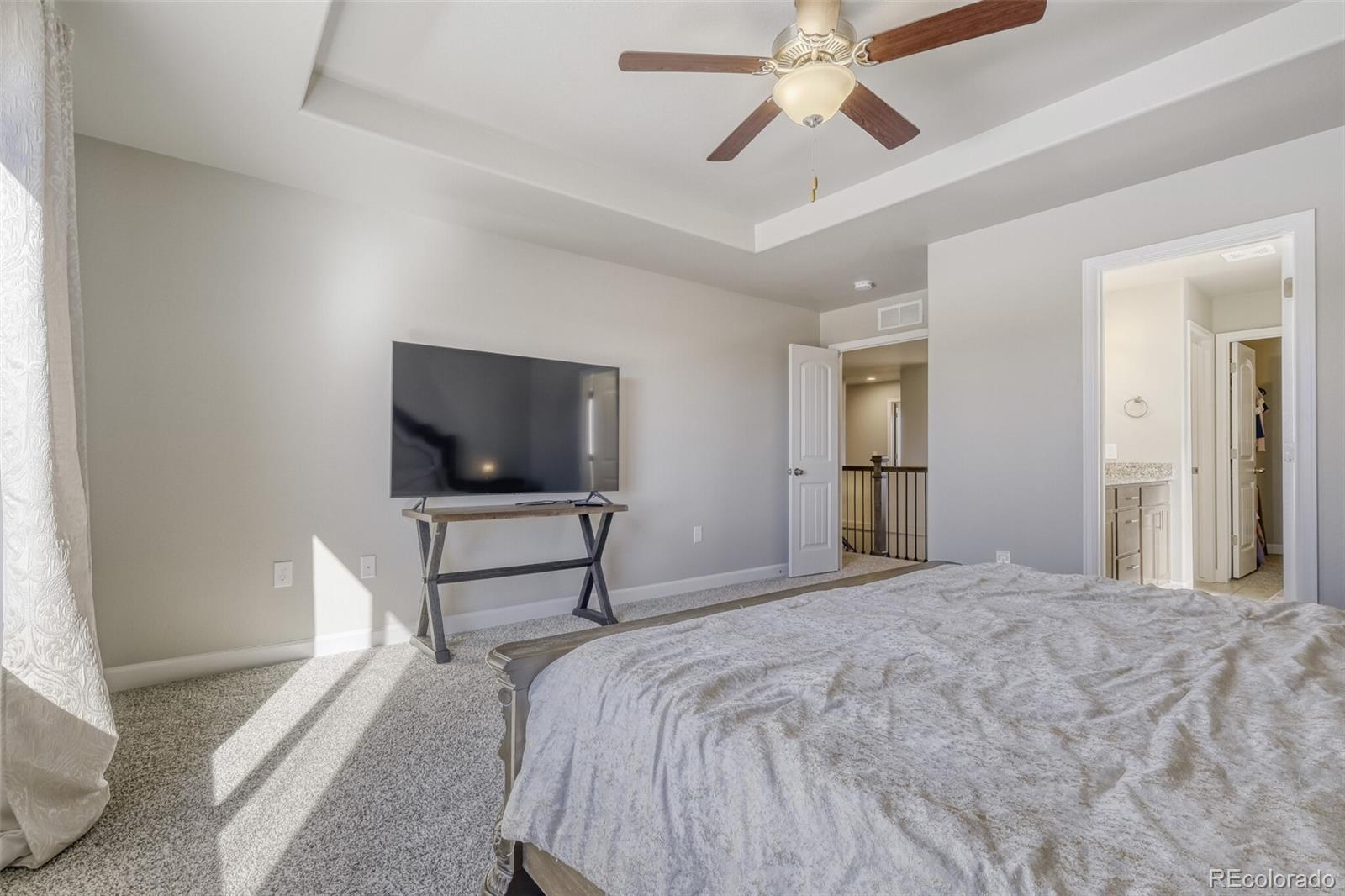 9093 Peaceful Valley Road Colorado Springs, CO 80925 - Photo 19 of 42 a bedroom with a bed and a flat screen tv
