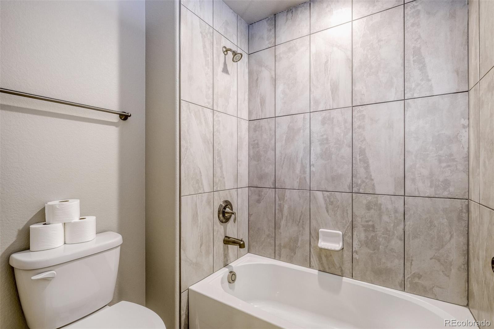 9093 Peaceful Valley Road Colorado Springs, CO 80925 - Photo 30 of 42 a white bath tub sitting next to a white toilet and a shower