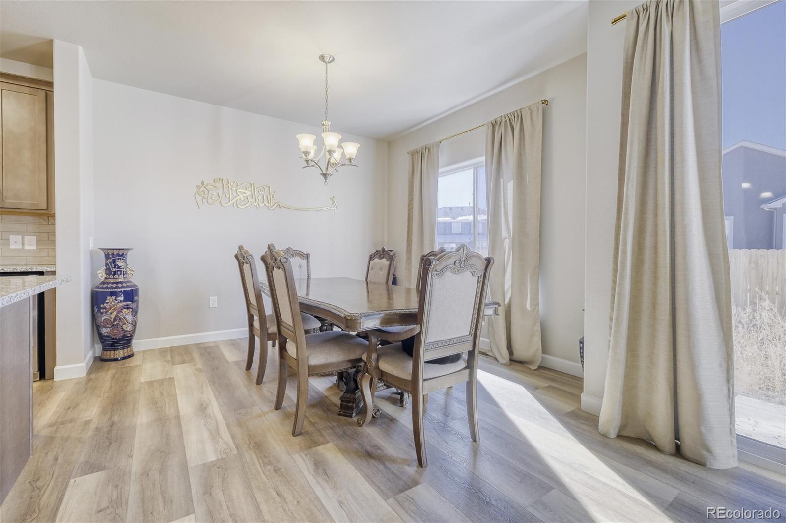 9093 Peaceful Valley Road Colorado Springs, CO 80925 - Photo 10 of 42 a view of a dining room with furniture and wooden floor