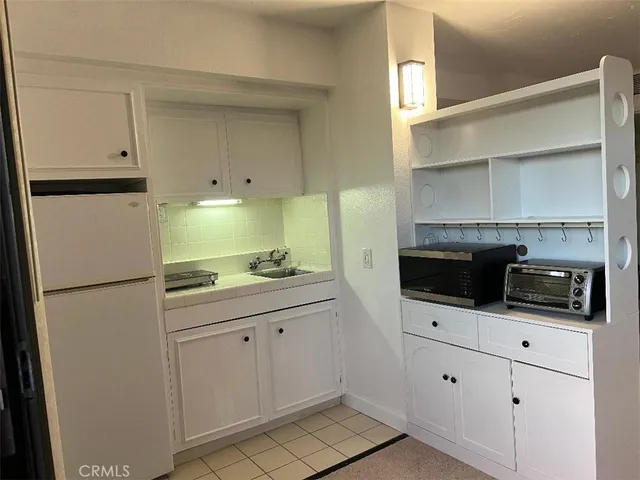 a kitchen with white cabinets and white appliances