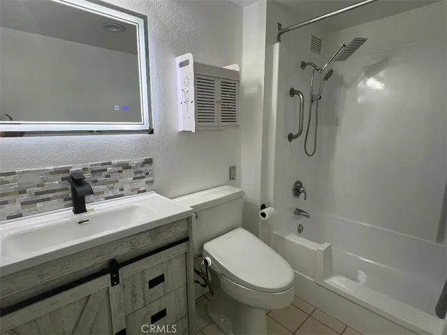 a bathroom with a sink toilet vanity and shower