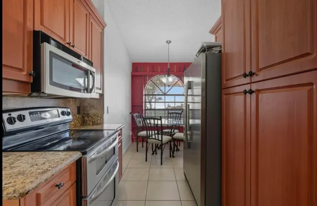 a kitchen with stainless steel appliances granite countertop a stove top oven a sink and cabinets
