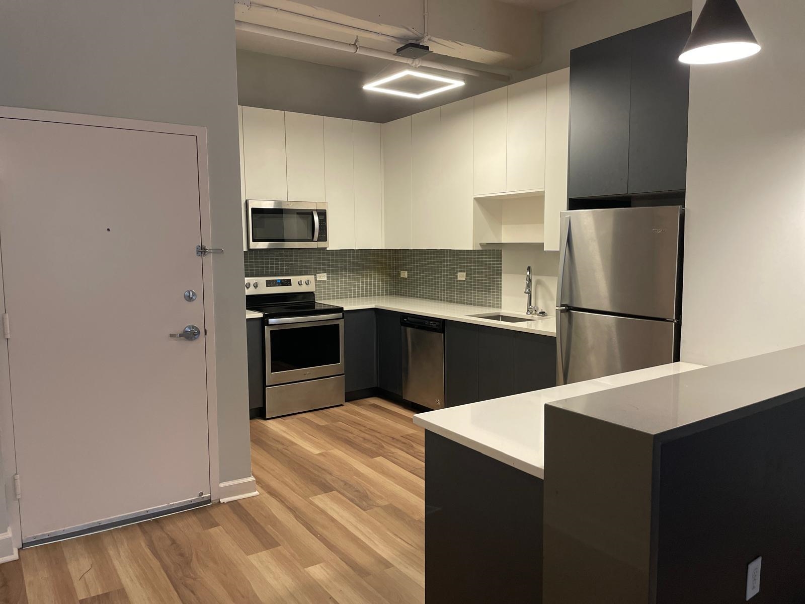 160 Lafayette Street, Unit 52306 Jersey City, NJ 07304 - Photo 16 of 25 a kitchen with stainless steel appliances granite countertop a refrigerator and a sink