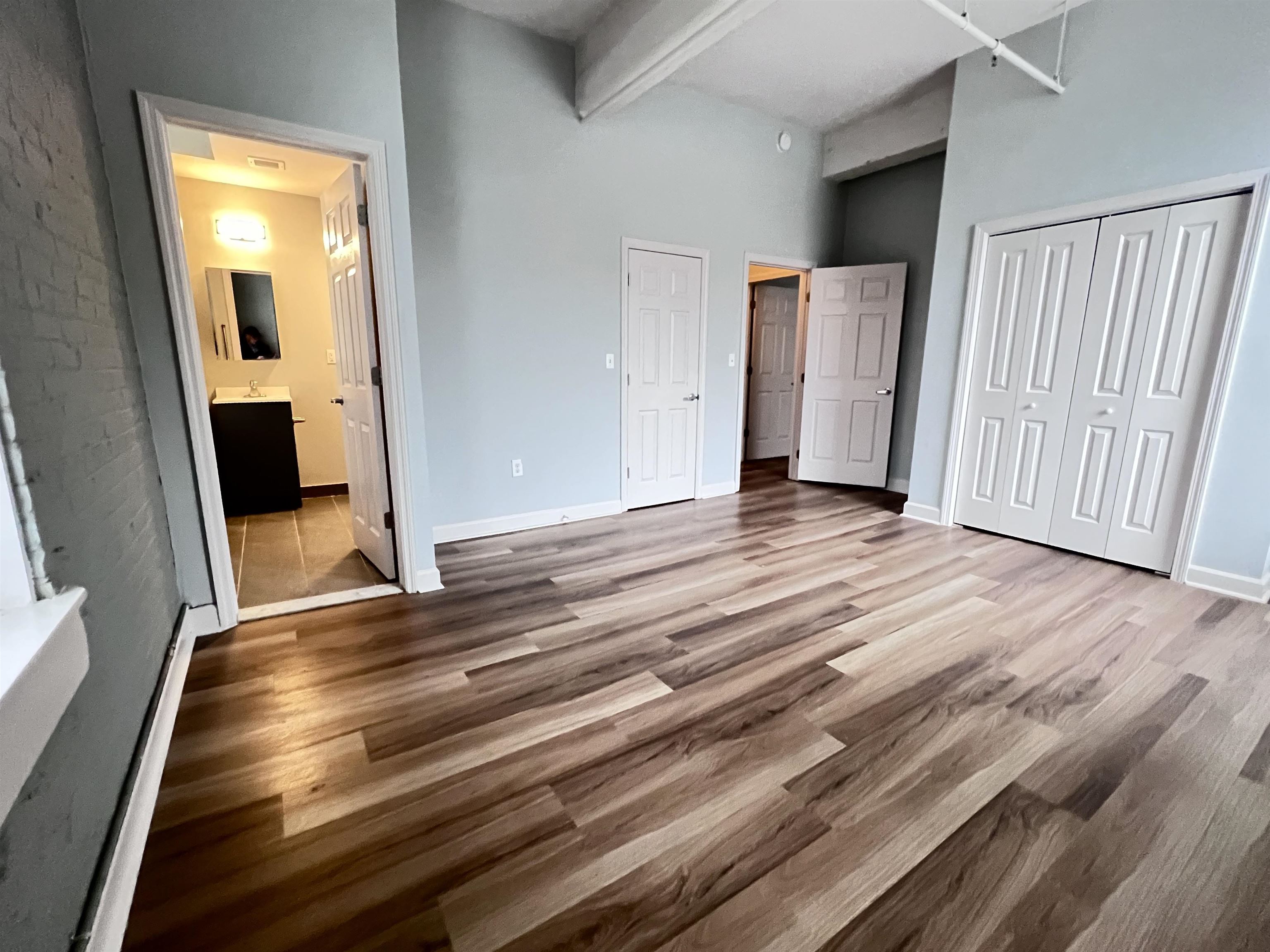 160 Lafayette Street, Unit 52306 Jersey City, NJ 07304 - Photo 3 of 25 an empty room with wooden floor and windows