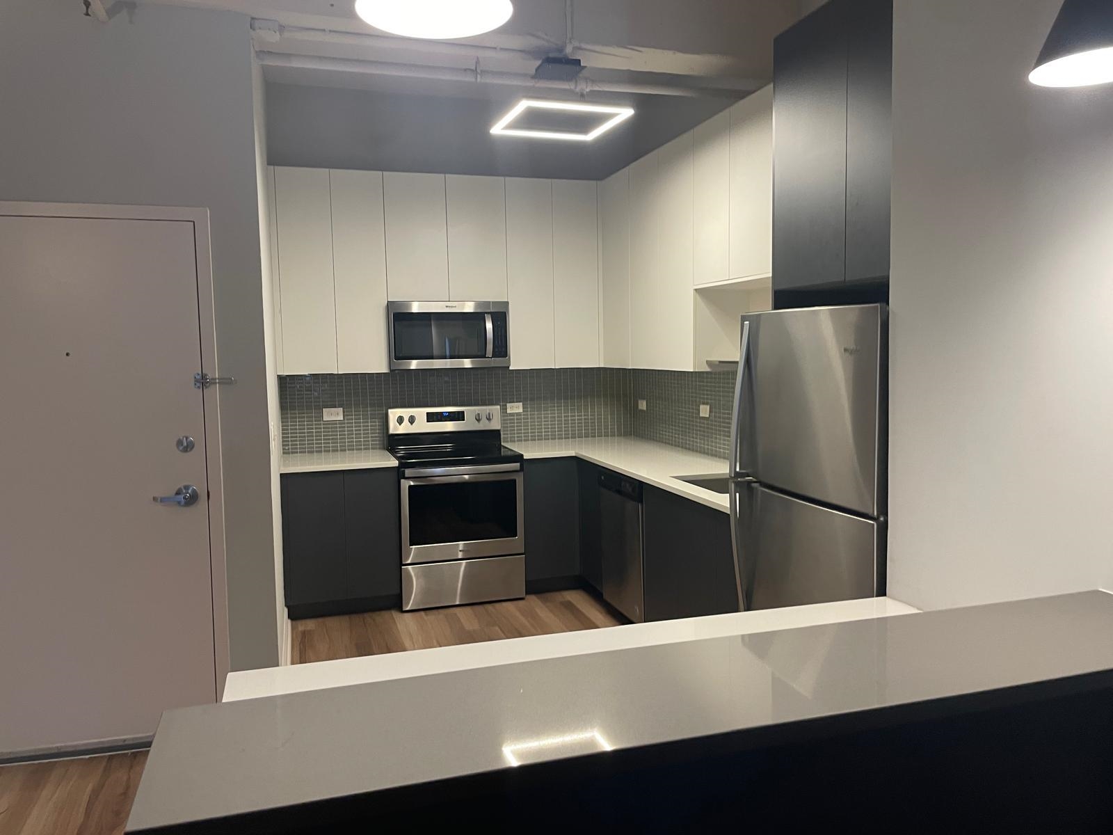 160 Lafayette Street, Unit 52306 Jersey City, NJ 07304 - Photo 9 of 25 a kitchen with stainless steel appliances a refrigerator a stove and a sink