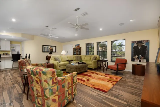 a living room with furniture kitchen view and a large window