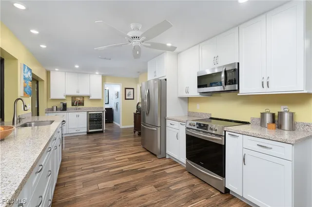 a large kitchen with stainless steel appliances kitchen island granite countertop a refrigerator and a sink