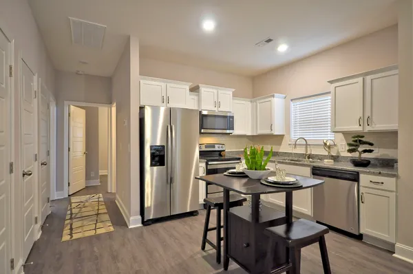 a kitchen with a refrigerator a stove a kitchen island and chairs in it