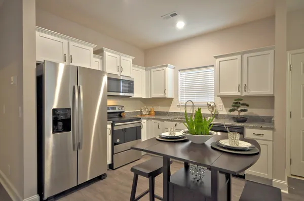 a kitchen with stainless steel appliances a refrigerator a stove a chimney and a center island