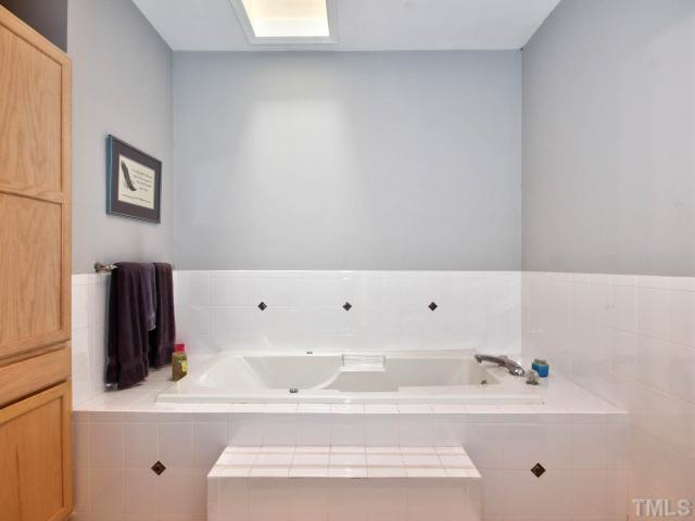 6820 Winding Ridge Road Zebulon, NC 27597 - Photo 14 of 25 Master bath has a large jetted tub with a skylight above it.