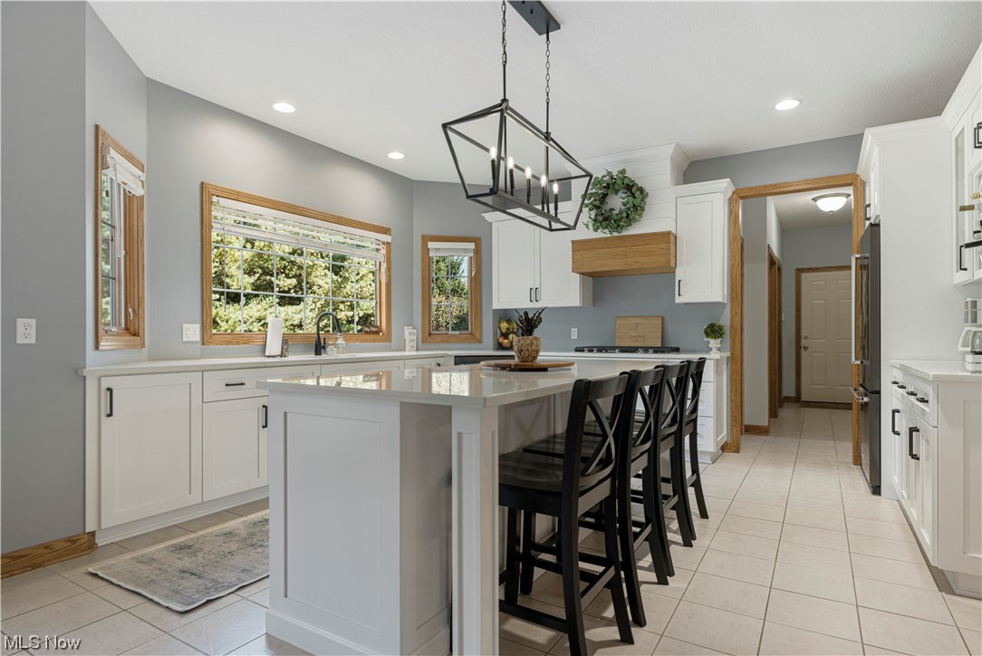 939 Pontius Road Mogadore, OH 44260 - Photo 6 of 35 Kitchen with decorative light fixtures, a center island, white cabinetry, and light tile floors