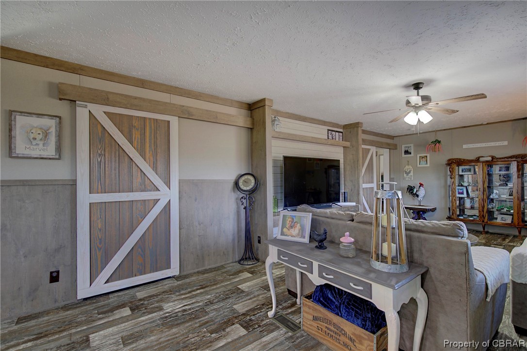 3029 Carsley Road Dendron, VA 23839 - Photo 20 of 26 Living room with a textured ceiling, dark hardwood / wood-style floors, and ceiling fan
