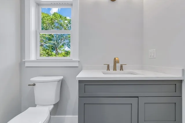 a bathroom with a sink a toilet and a window