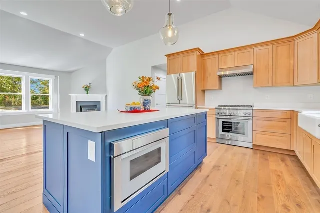 a kitchen with stainless steel appliances granite countertop a stove a sink dishwasher and a refrigerator with wooden floor