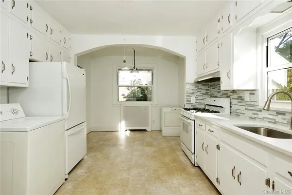 a kitchen with stainless steel appliances a refrigerator sink and cabinets