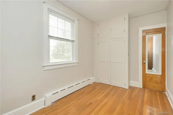 an empty room with a window and wooden floor
