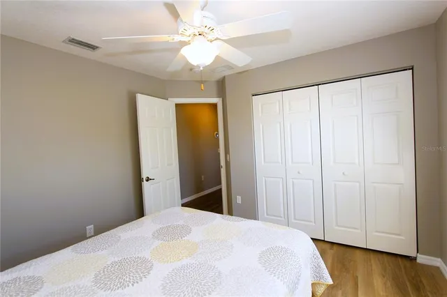 a bedroom with a bed and a chandelier fan