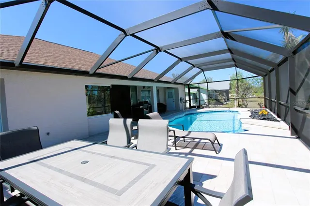 a view of a patio with a table and chairs under an umbrella