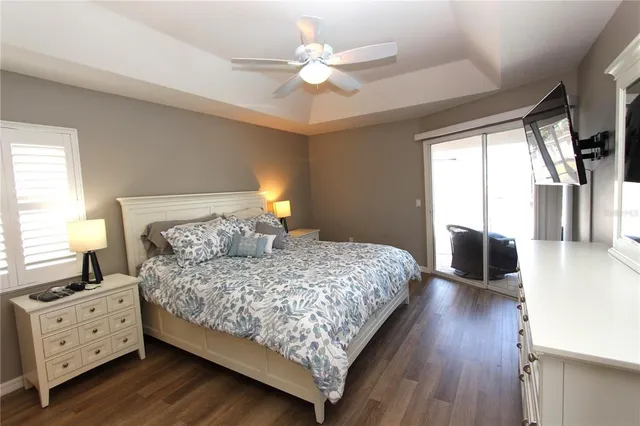 a bedroom with a large bed and a chandelier fan