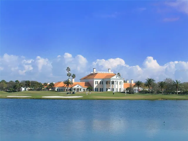 a dining hall with stainless steel appliances kitchen island granite countertop a table chairs and a wooden floor