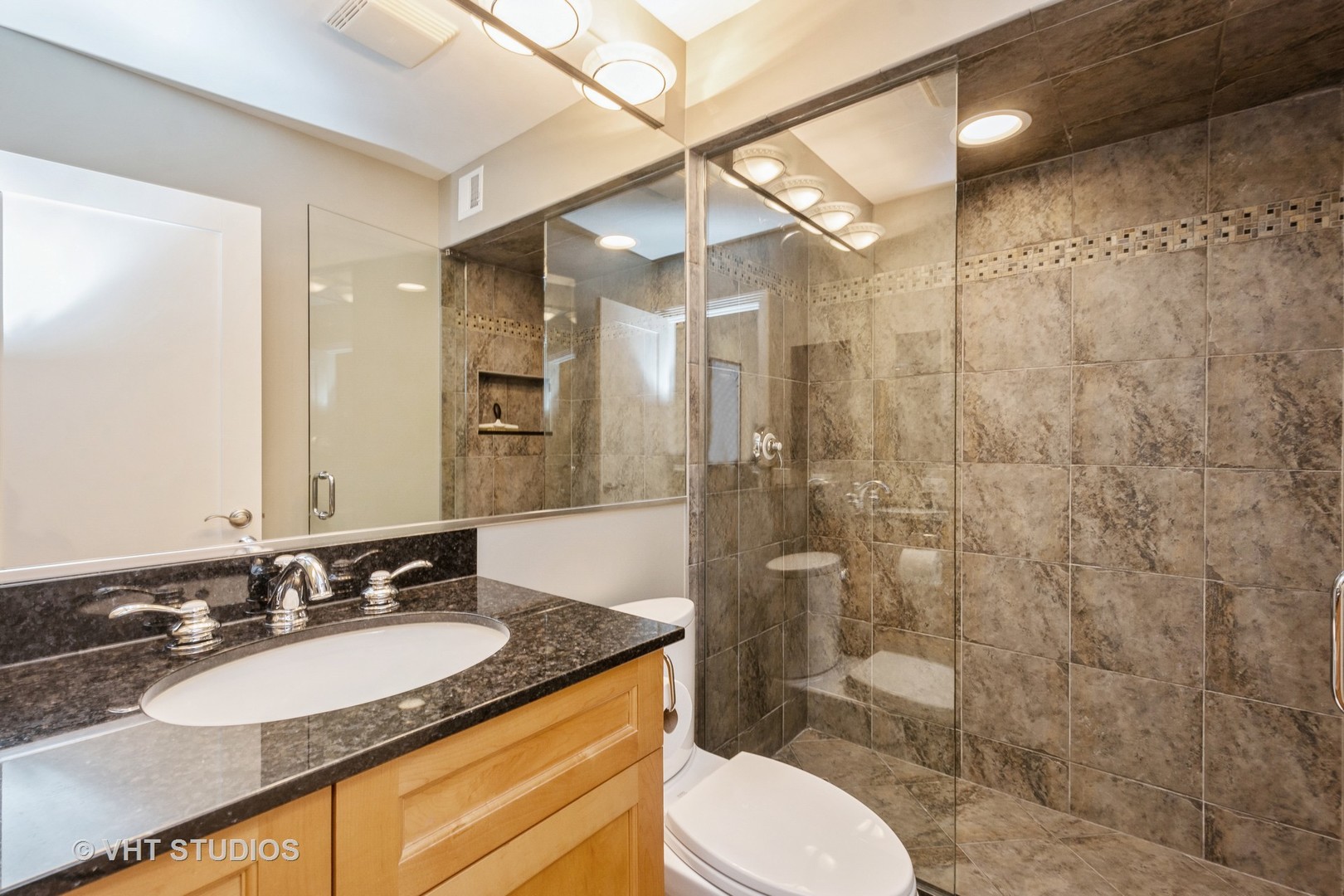 1000 North State Street, Unit 13 Chicago, IL 60610 - Photo 21 of 45 a bathroom with a granite countertop sink toilet a mirror and shower