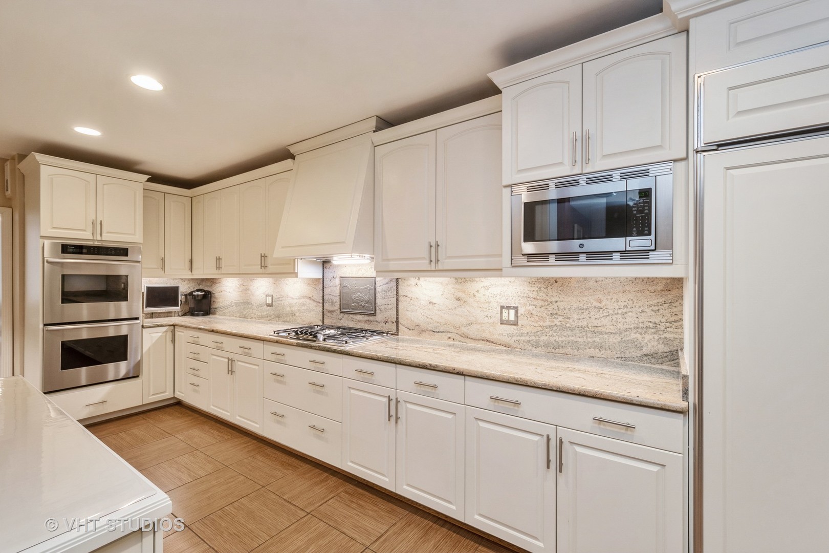 1000 North State Street, Unit 13 Chicago, IL 60610 - Photo 8 of 45 a kitchen with granite countertop white cabinets and stainless steel appliances
