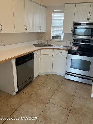 a kitchen with cabinets stainless steel appliances and a window