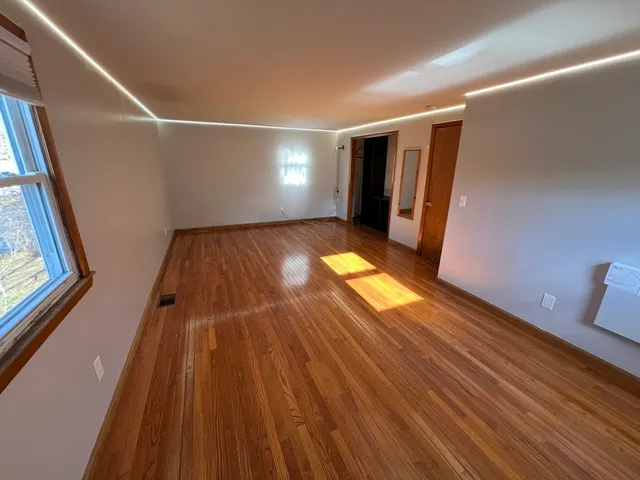 a view of empty room with wooden floor