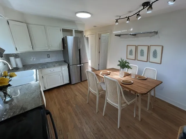 a kitchen with a table chairs refrigerator and microwave