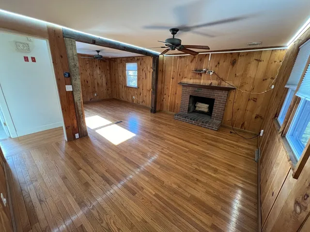 a view of a livingroom with wooden floor and a fireplace